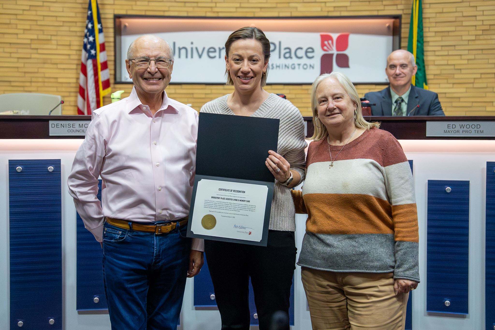 Group of people standing for a photo holding a certificate in Council Chambers