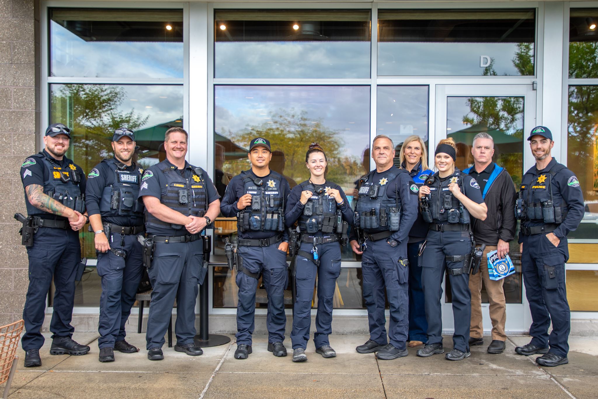 Group of Officers and Safety team standing for a photo in front of Starbucks