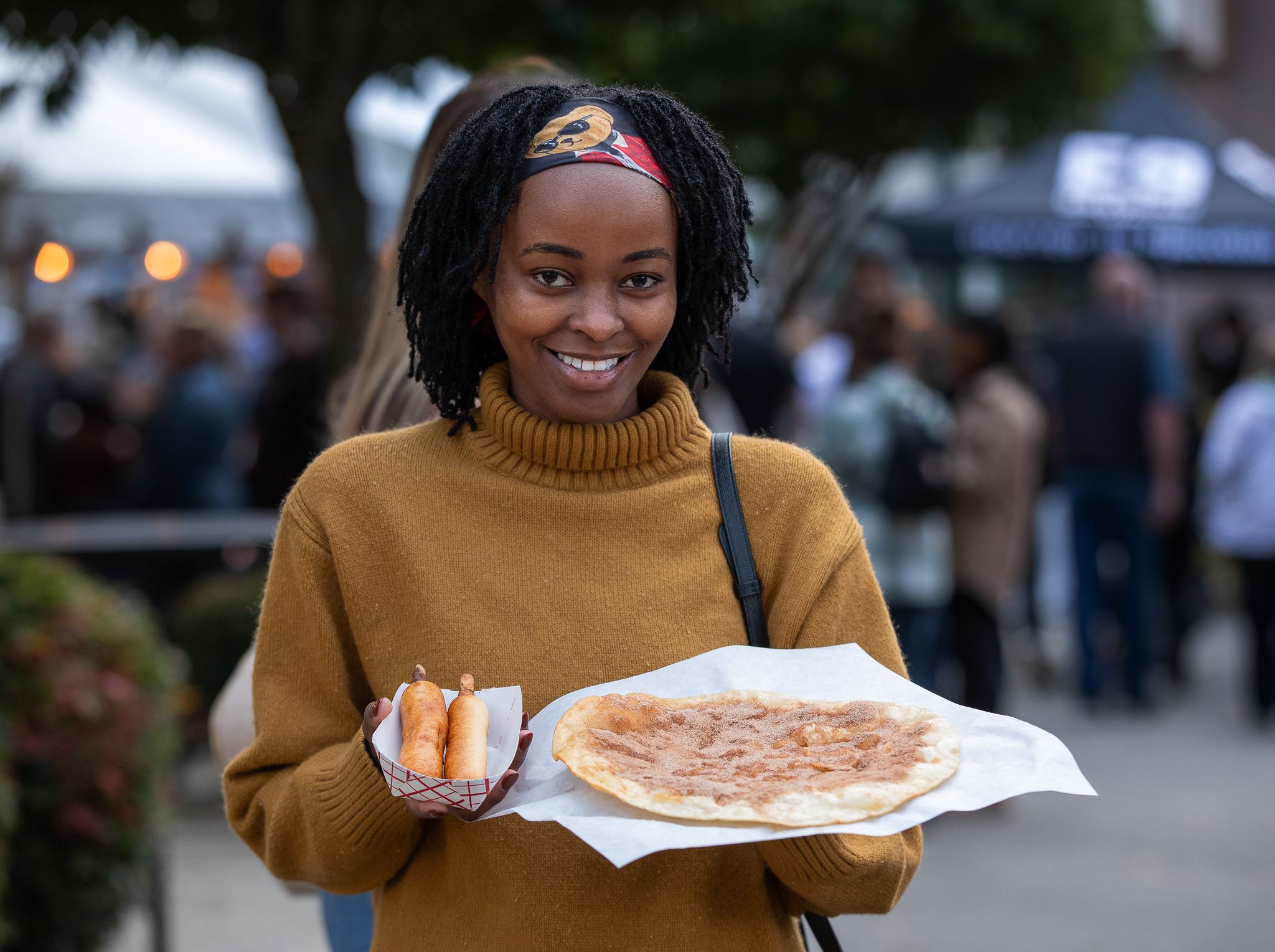 woman holding pizza and corndogs